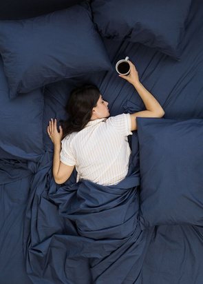 A woman asleep on navy bedding