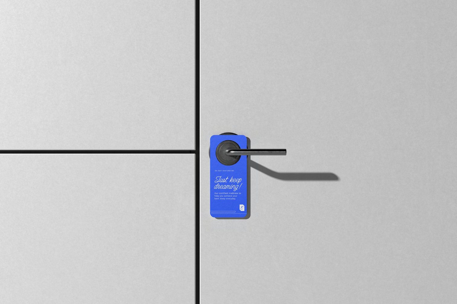A blue Comfortaire 'Just keep dreaming' door hanger on a hotel room door